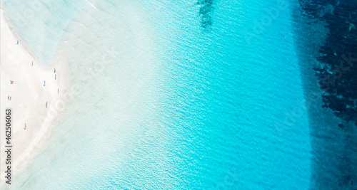 View from above, stunning aerial view of La Pelosa beach, a white sand beach bathed by a crystal clear water with beautiful shades of turquoise and blue. Stintino, Sardinia, Italy.