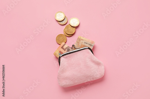 Small wallet with money on pink background