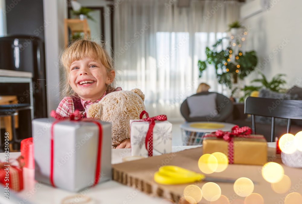 Smiling cute little girl hugging a teddy bear, happy about holidays and presents Smiling cute little girl hugging a teddy bear, happy about holidays and presents