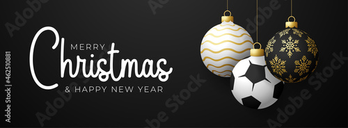 soccer Sport Christmas card. Merry Christmas sport greeting card. Hang on a thread soccer, football ball as a xmas ball and golden bauble on black horizontal background. Sport Vector illustration.