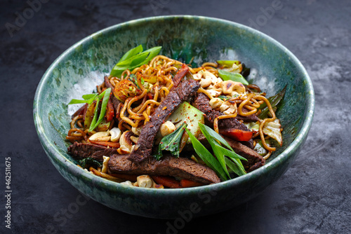 Modern style pad Thai beef with angus roast beef slices, noodles and vegetable served as close-up in a Nordic design bowl