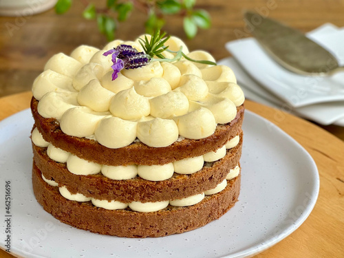 Carrot cake decorated with cream cheese frosting and fresh lavender flowers