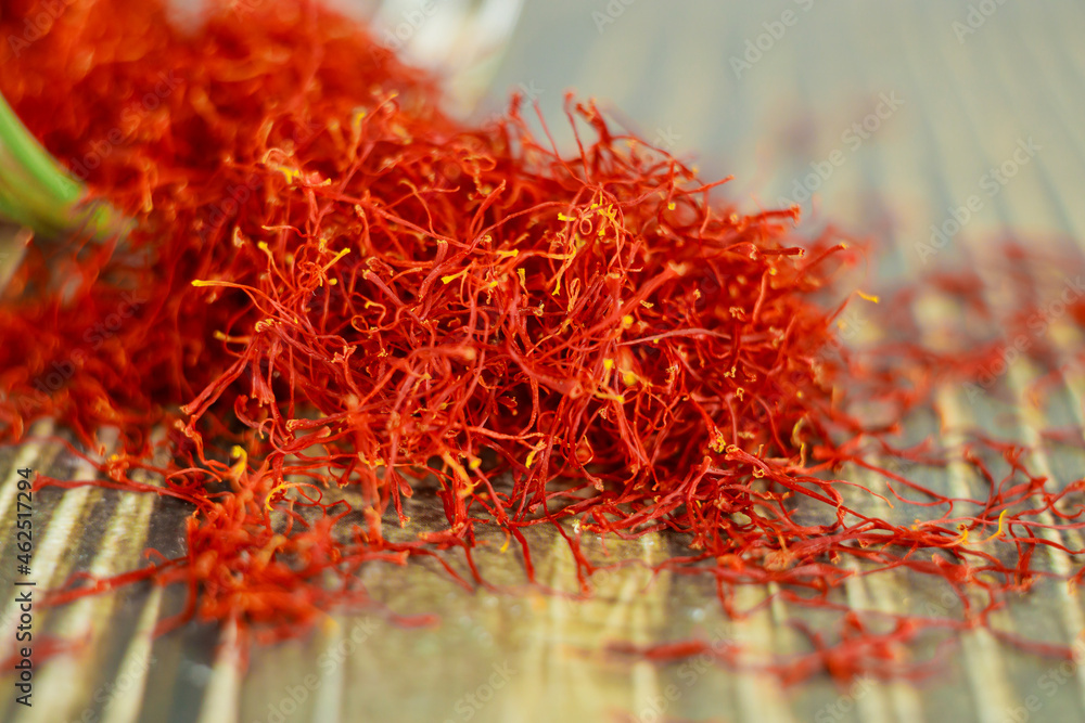 Naklejka premium Close up of oriental saffron dried spice on wooden spoon.