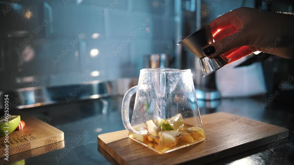 tea drink. making tea. preparation of drinks. close-up. tea master pours sweet syrup or juice into a glass teapot with fruit pieces for further preparation of special hot fruit tea drink tea drink. making tea. preparation of drinks. close-up. tea master pours sweet syrup or juice into a glass teapot with fruit pieces for further preparation of special hot fruit tea drink