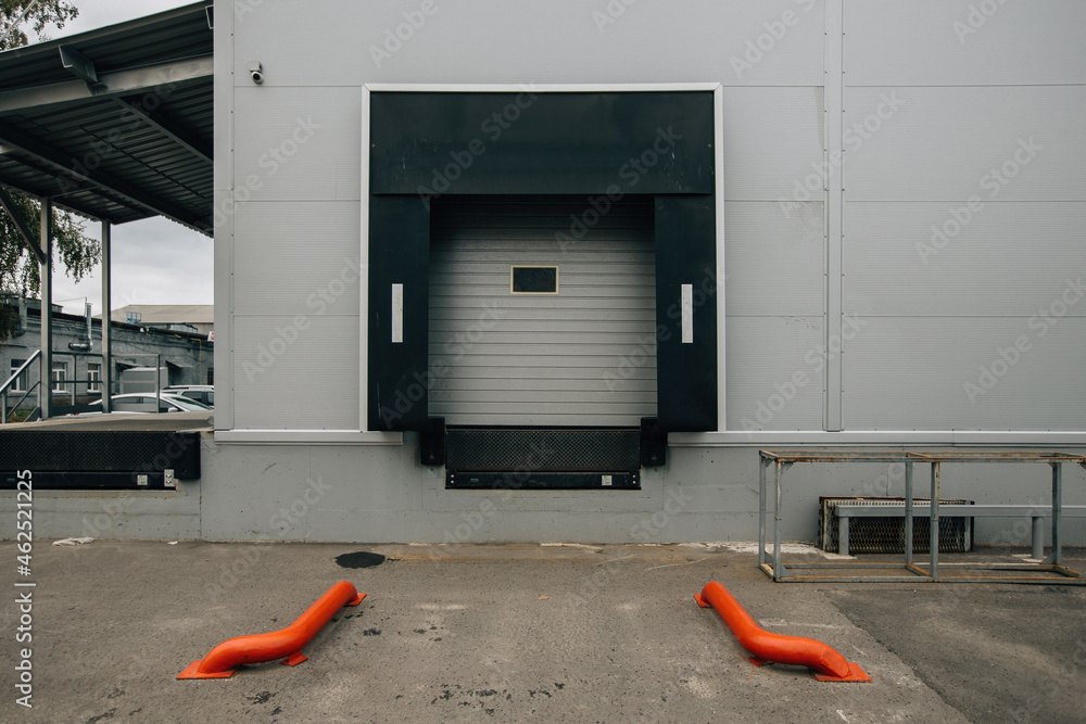 Closed door of transport terminal for truck deliveries and loading - obrazy, fototapety, plakaty 