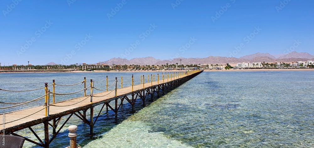 Long wooden bridge on the sea. Red Sea in Egypt. Holidays at sea in Egypt.