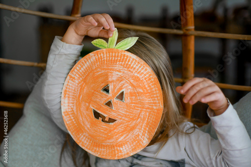 Children making Halloween decorations from colored paper photo