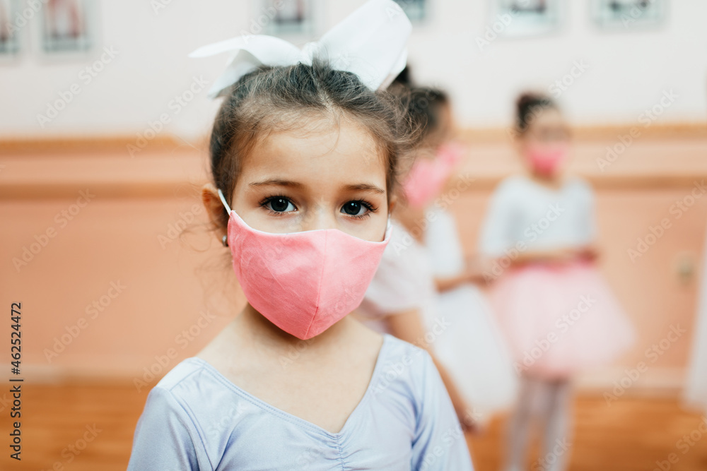 Group of beautiful little girls with protective face masks practicing ballet at dancing class. Coronavirus, Covid-19 concept. - obrazy, fototapety, plakaty 