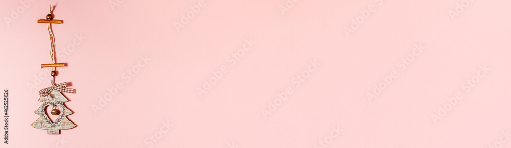 Banner of flat lay of wooden christmas decoration tree with heart inside it and jingle bell on pink. Christmas holidays concept from above with copy space Banner of flat lay of wooden christmas decoration tree with heart inside it and jingle bell on pink. Christmas holidays concept from above with copy space