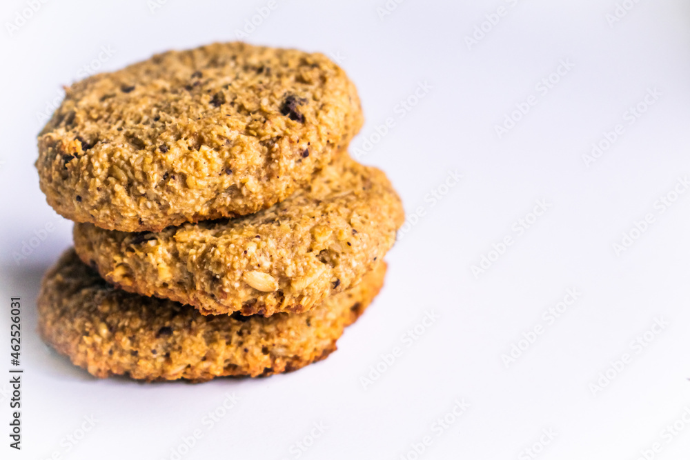 Close up of an isolated stack of healthy oatmeal, chocolate and nuts cookies on a white background. Fitness lifestyle and low calories diet snack concept. Selective focus and low depth of field. Close up of an isolated stack of healthy oatmeal, chocolate and nuts cookies on a white background. Fitness lifestyle and low calories diet snack concept. Selective focus and low depth of field.
