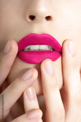 Closeup of beautiful young woman   s lips and bright vivid pink make up. Portrait of fashion beauty model with colorful professional makeup. Macro  selective focus