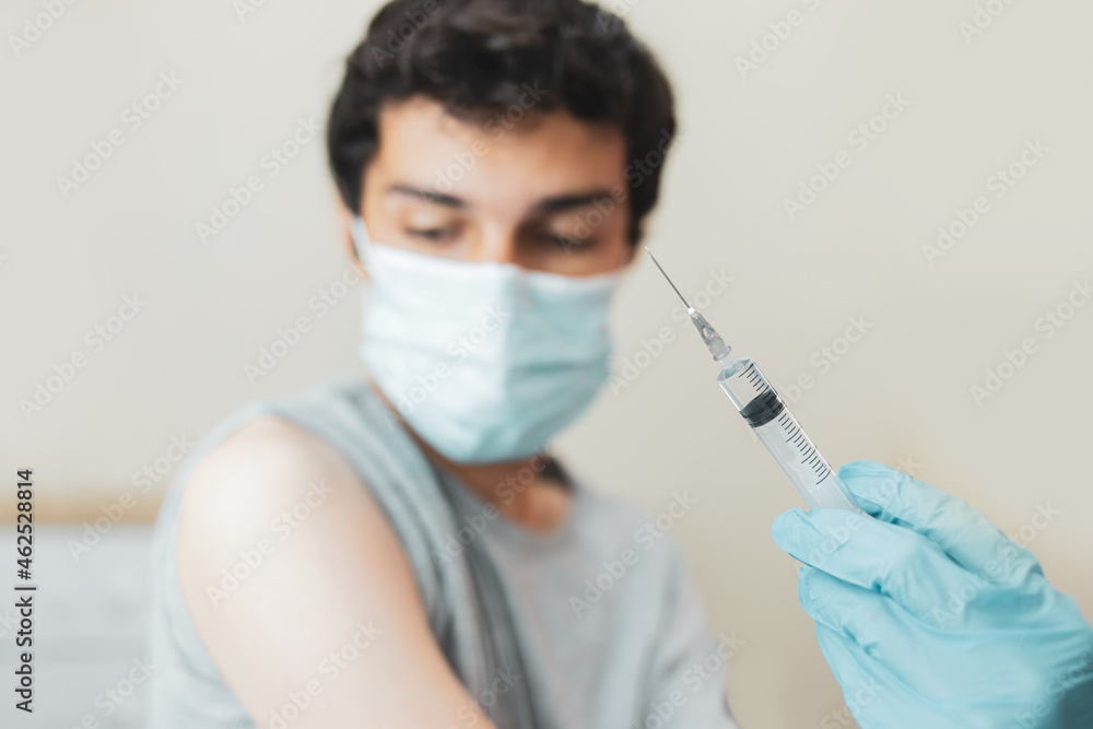 Young man receiving the coronavirus vaccine. Concept of immunization campaign against coronavirus for young people. Young man receiving the coronavirus vaccine. Concept of immunization campaign against coronavirus for young people.