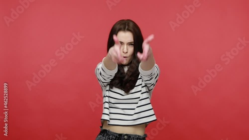 Portrait of positive woman dancing, moving to the rhythm enjoying a festive atmosphere, relaxing, wearing casual style long sleeve shirt. Indoor studio shot isolated on red background. photo