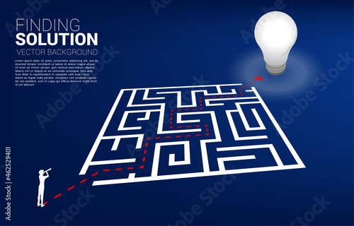 Silhouette of businessman looking through telescope standing on route into maze to goal. Business concept for problem solving and finding idea.