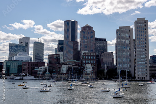 Sailboats anchored in front of the Boston skyline