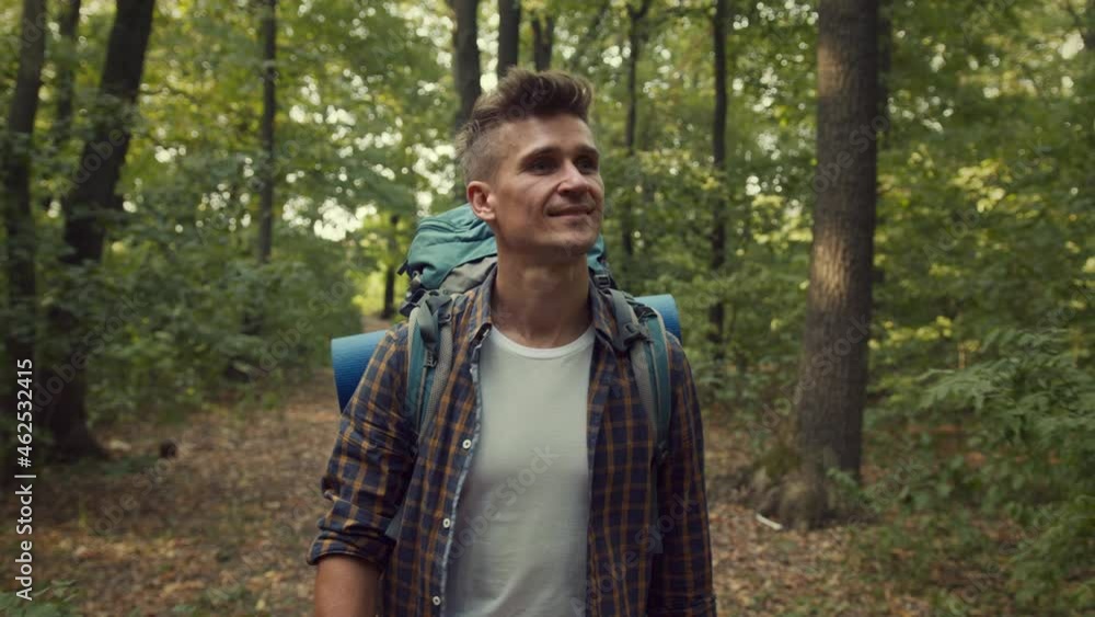 Little travel. Young man backpacker exploring autumn woods, walking alone in forest with back pack and camping equipment Little travel. Young man backpacker exploring autumn woods, walking alone in forest with back pack and camping equipment