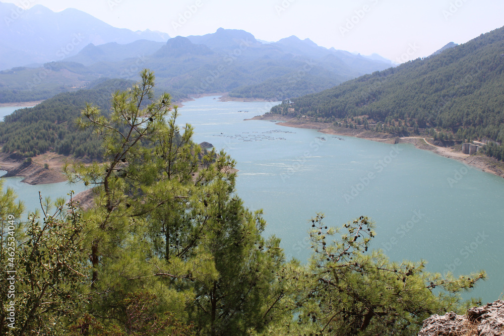 turquoise bay in sunny, dissected by green hills covered with greenery