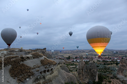two large and many small balloons with baskets for people in the sky