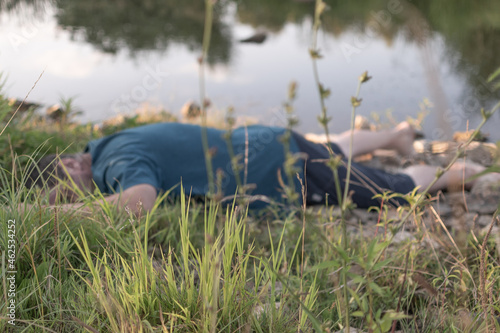 the corpse of a dead man lies on the shore by the water