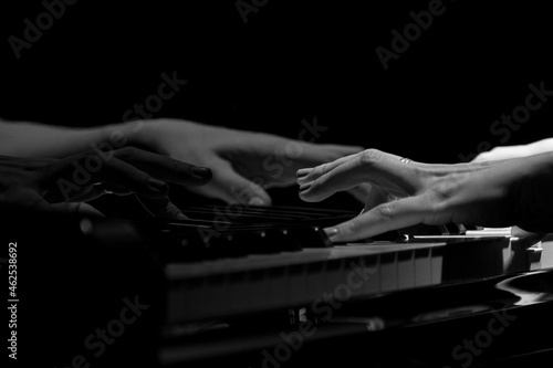 black and white of woman hands playing on a piano