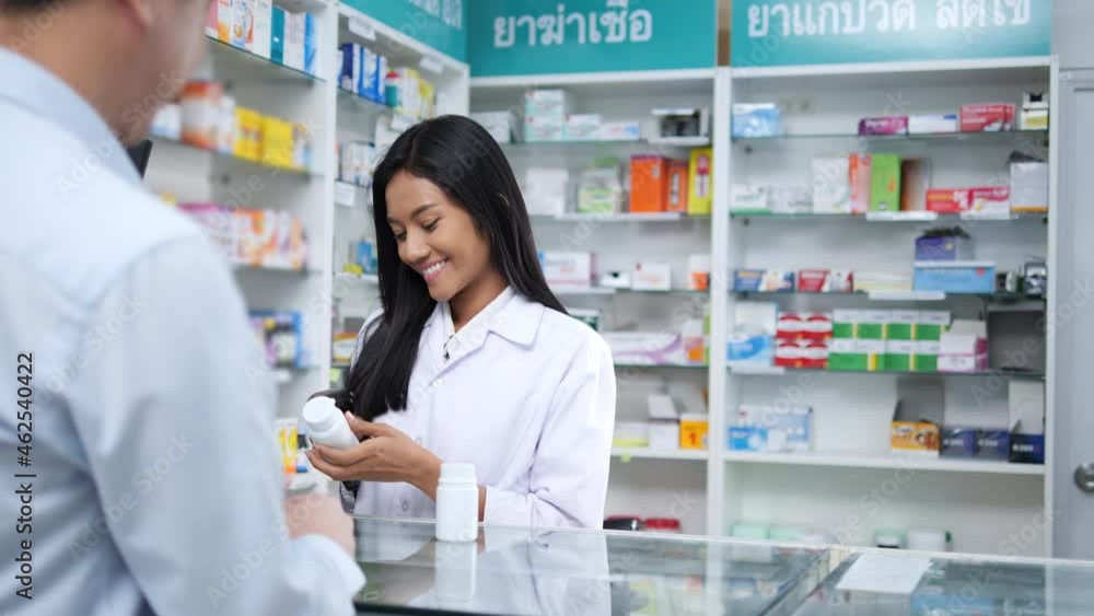 Pharmacist woman sell drug to man for treatment with medicine in pharmacy store at hospital. Asian man receive medicine from young doctor. Pharmacist woman sell drug to man for treatment with medicine in pharmacy store at hospital. Asian man receive medicine from young doctor.
