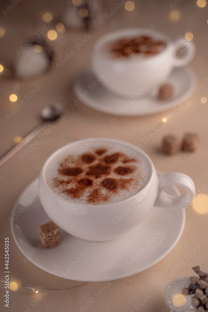 a cup of cappuccino with cinnamon on a festive New Year's table with lights a cup of cappuccino with cinnamon on a festive New Year's table with lights