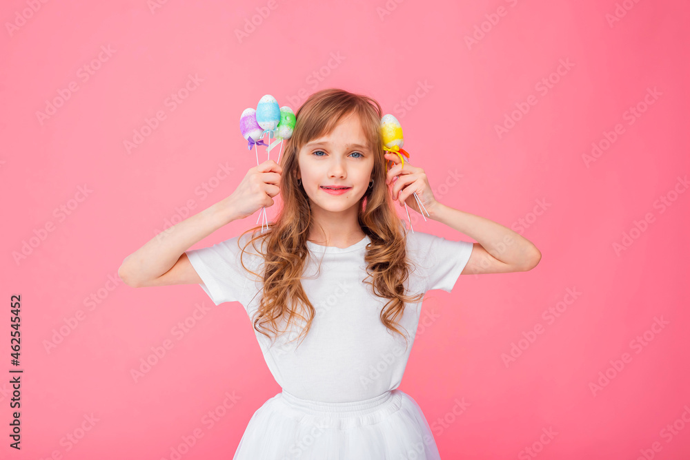 Cute blonde girl 8-9 years old in a white T-shirt and skirt holds Easter eggs isolated on a pink background. Happy Easter, holidays, traditions. Cute blonde girl 8-9 years old in a white T-shirt and skirt holds Easter eggs isolated on a pink background. Happy Easter, holidays, traditions.