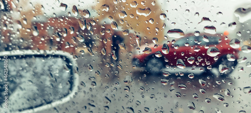 View from the car to the street. Raindrops on the glass.