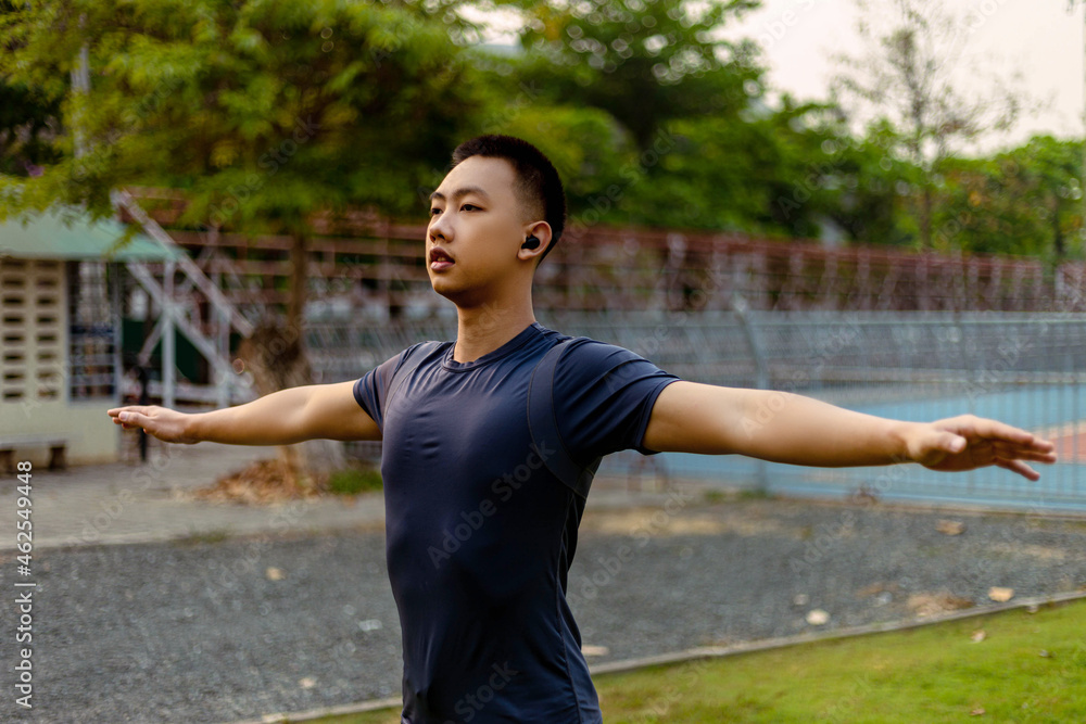 Sports and recreation concept a male adolescent doing warm-up movements as raising his body temperature and increasing blood flow to his muscles Sports and recreation concept a male adolescent doing warm-up movements as raising his body temperature and increasing blood flow to his muscles