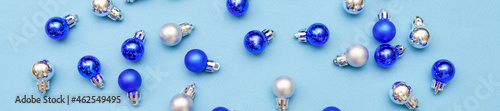 Blue and silver glitter christmas balls pattern. Flat lay, top view on a blue background. Christmas concept