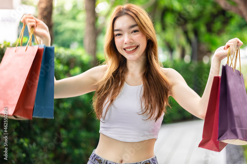 Happy woman with shopping bags enjoying in shopping. Girl holding colour paper bag.Friends walking in shopping mall.time shopping coronavirus crisis or covid19 outbreak.