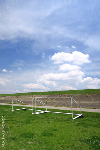 初夏のゴールポストのある江戸川河川敷のサッカー場と護岸のある土手風景 © smtd3