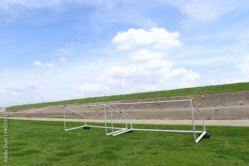 初夏のゴールポストのある江戸川河川敷のサッカー場と護岸のある土手風景