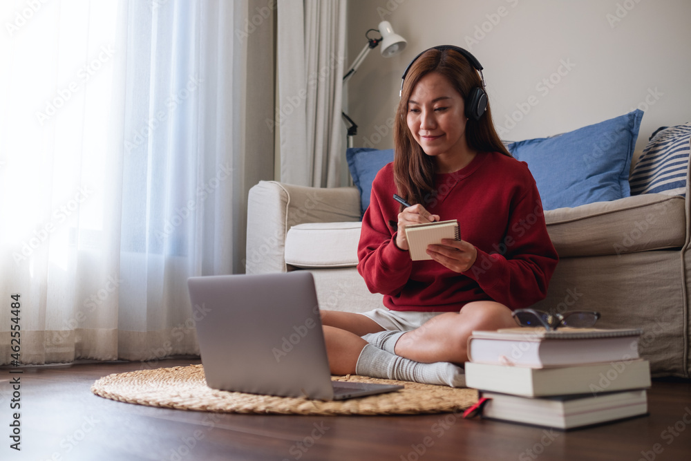 A young woman with headphone using laptop computer for online study at home A young woman with headphone using laptop computer for online study at home