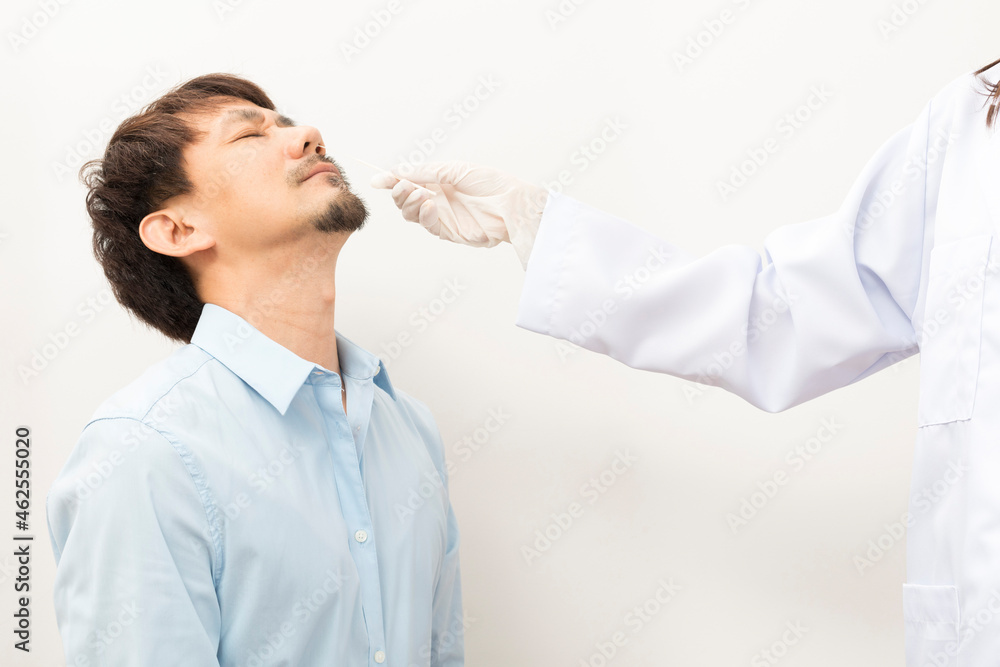 Covid diagnostic procedure. Doctor making nasal PCR test for adult asian man, using sterile swab stick, Coronavirus COVID-19 ATK diagnostic. Covid diagnostic procedure. Doctor making nasal PCR test for adult asian man, using sterile swab stick, Coronavirus COVID-19 ATK diagnostic.