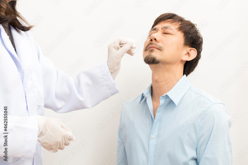 Covid diagnostic procedure. Doctor making nasal PCR test for adult asian man, using sterile swab stick, Coronavirus COVID-19 ATK diagnostic. Covid diagnostic procedure. Doctor making nasal PCR test for adult asian man, using sterile swab stick, Coronavirus COVID-19 ATK diagnostic.