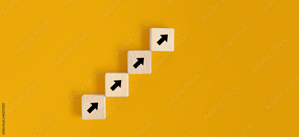 Square wooden blocks are placed on a yellow background, on the wooden blocks there are arrow contracts and line up. Wood block concept, banner with copy space for text, poster, mockup template. Square wooden blocks are placed on a yellow background, on the wooden blocks there are arrow contracts and line up. Wood block concept, banner with copy space for text, poster, mockup template.