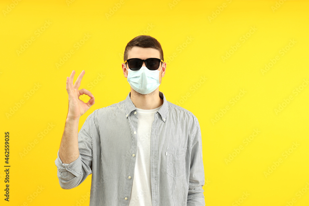 Traveling concept during coronavirus with young man on yellow background Traveling concept during coronavirus with young man on yellow background