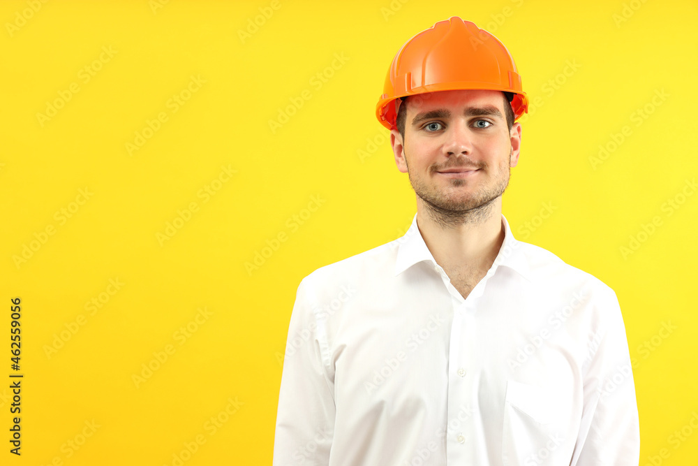 Businessman builder on yellow background, space for text