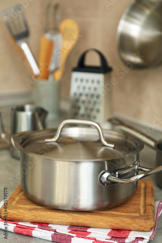 Concept of kitchen utensil with metal pot, selective focus