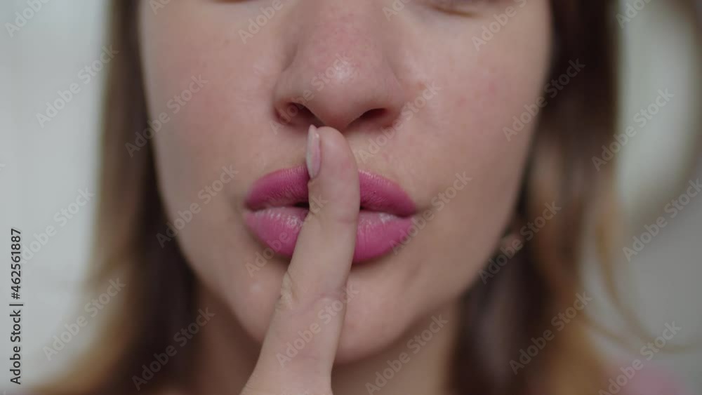 Close-up of attractive adult woman with finger on lips showing to keep silence, be quiet and making hush gesture. Close-up of attractive adult woman with finger on lips showing to keep silence, be quiet and making hush gesture.