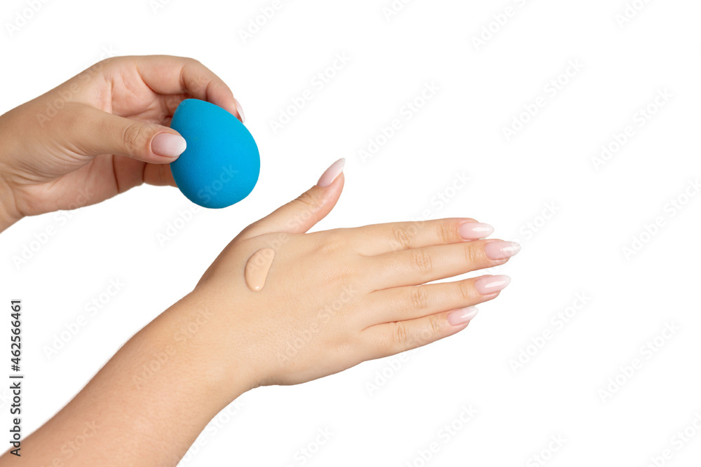 Woman holding beauty blender with a drop of a foundation Woman holding beauty blender with a drop of a foundation