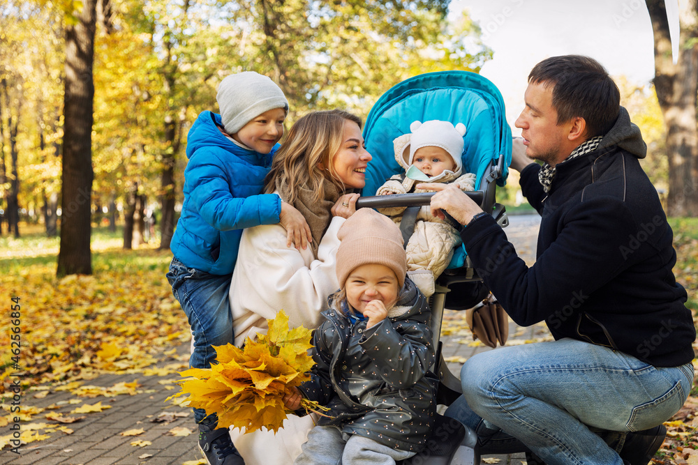 Young family with small children in the park. Happy smiling parents. Love and tenderness. Golden autumn season. Young family with small children in the park. Happy smiling parents. Love and tenderness. Golden autumn season.