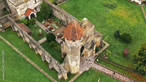Aerial drone view of the ruins of medieval Cistercian abbey in Romania. Carta Monastery, medieval buidlings, greenery, visitors