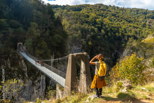 A young woman looking at the Passerelle Holtzarte, Larrau. In the forest or jungle of Irati, north of Navarra in Spain and the Pyrenees-Atlantiques of France photo