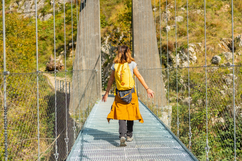 A hiker crossing the Holtzarte suspension bridge, Larrau. In the forest or jungle of Irati, Pyrenees-Atlantiques of France photo