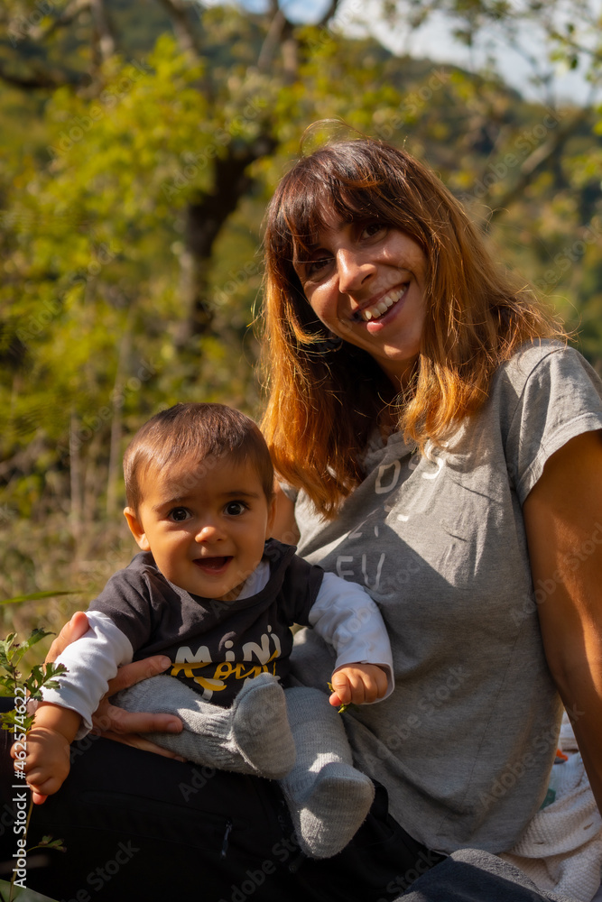 A mother with her baby in the forest near the Holtzarte suspension bridge, Larrau. In the forest or jungle of Irati, Pyrenees-Atlantiques of France