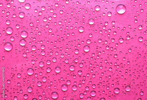 Water drops on glass. Pink background with raindrops on glass