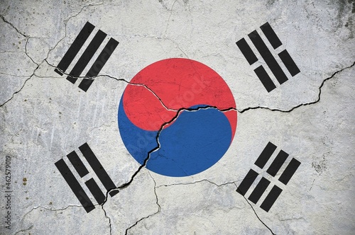 An image of the Republic of Korea flag on a wall with a crack.