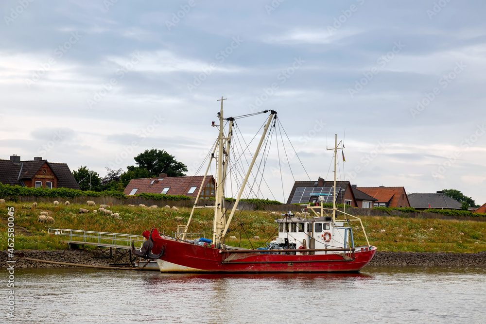 Roter Fischkutter am Deich an der Elbe